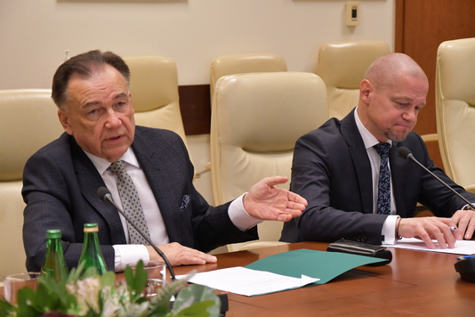 Marszałek przy stole tłumaczy ambasadorowi zalety inwestowania na Mazowszu