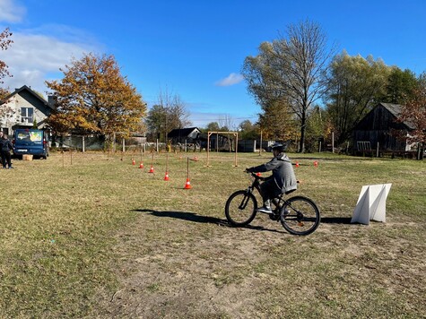 Uczeń jedzie rowerem przez boisko
