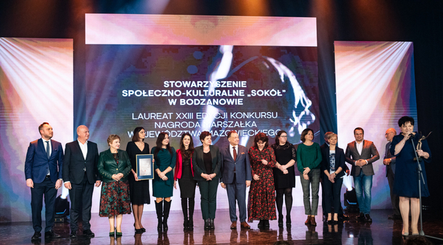 Marszałek i Elżbieta Lanc pozują do zdjęcia z laureatami - stowarzyszeniem społeczno-kulturalnym Sokół z Bodzanowa