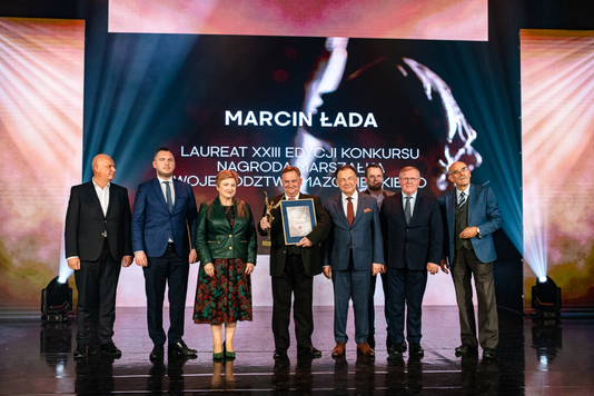 Marszałek i Elżbieta Lanc pozują do zdjęcia z laureatem - Marcinem Ładą