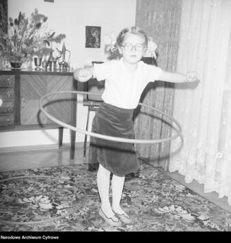 dziewczynka kręci obręcz hula hop wokół bioder