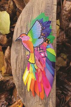 Broszka w kształcie lecącego ptaka, wykonana z kolorowych wstążek i haftu.