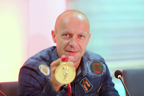 Sędzia piłkarski Szymon Marciniak z medalem mistrzostw świata w dłoni
