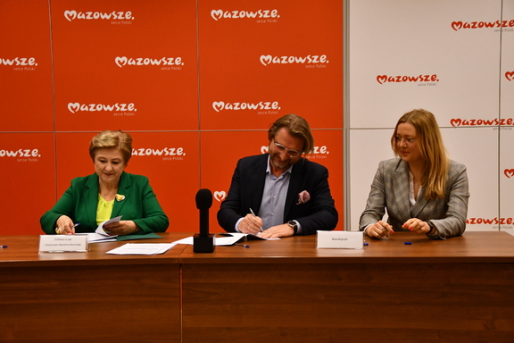 Członek zarządu Elżbieta Lanc i dwóch przedstawicieli beneficjenta podpisują umowy