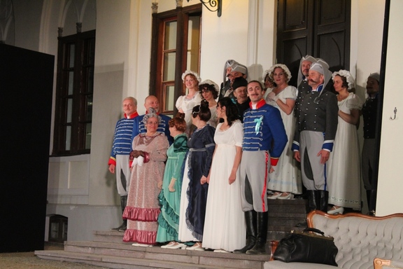 aktorzy w kostiumach z epoki stoją na schodach oficyny dworskiej