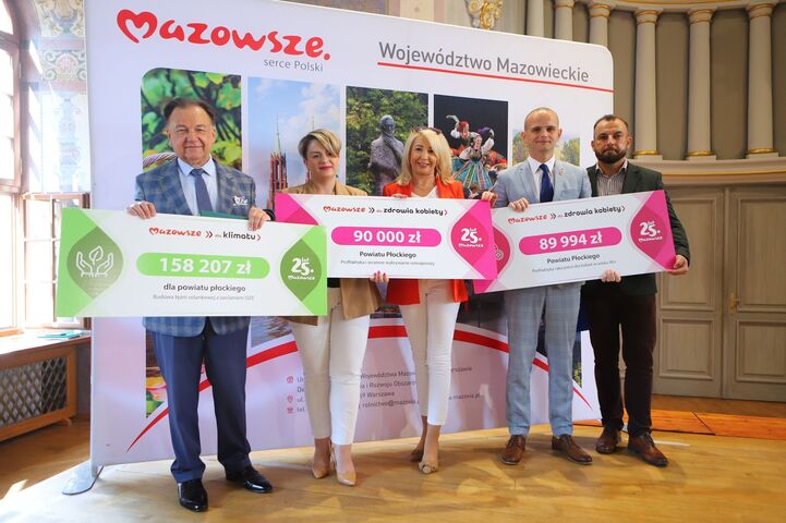 Przedstawiciele płockiego starostwa wraz z marszałkiem Adamem Struzikiem prezentują czeki z dofinansowaniem dla powiatu płockiego