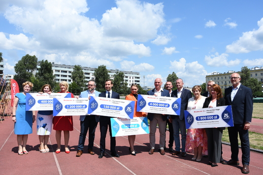 Władze samorządu Mazowsza z władzami Pragi-Południe prezentują czeki na tle stadionu Podskarbińska w Warszawie 