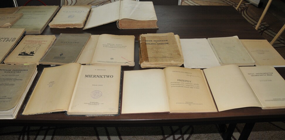 Stare wydania ustaw i przepisów prawnych - książki rozłożone na stole.