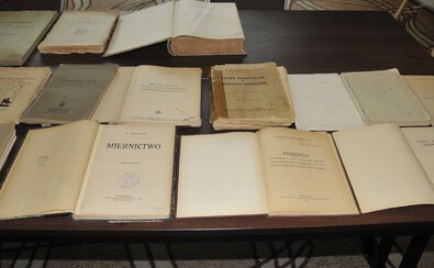 Stare wydania ustaw i przepisów prawnych - książki rozłożone na stole.
