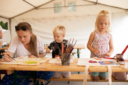 Chłopiec i dziewczynka malują farbami na kartce papieru