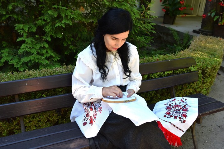 Kobieta w tradycyjnym stroju haftuje