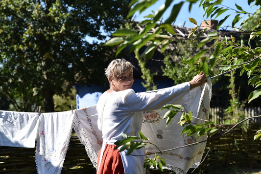 Kobieta wiesza pranie na sznurku w ogrodzie 