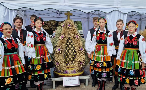 Członkowie zespołu w tradycyjnych strojach z wieńcem dożynkowym z Mazowsza