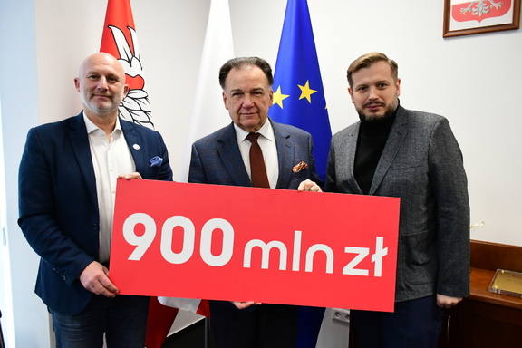 Władze samorządu z banerem z kwotą 900 mln zł