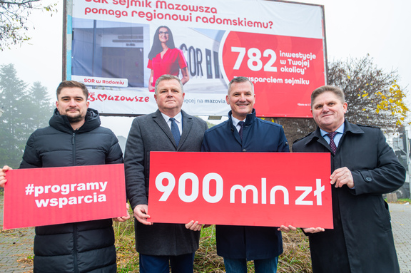 Wicemarszałek Rafał Rajkowski i przedstawiciele samorządu z banerem 900 mln zł wsparcia