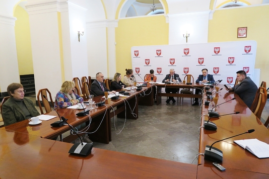 Uczestnicy posiedzenia siedzą przy stole w sali konferencyjnej Sejmiku Województwa Mazowieckiego