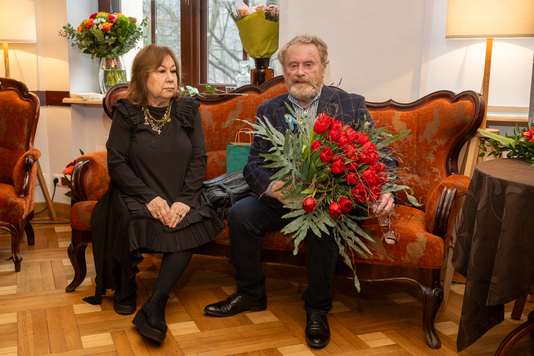 Daniel Olbrychski z żoną siedzą na sofie.