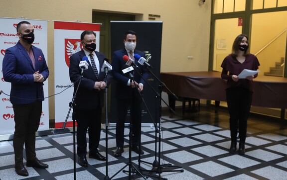 Marszałek Adam Struzik, radny Mirosław Orliński oraz radny Wojnarowski Stoją przed mikrofonami na sali konferencyjnej. Marszałek jest wysunięty do przodu, przemawia do mikrofonu