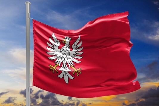 Flaga Mazowsza powiewa na tle błękitnego nieba